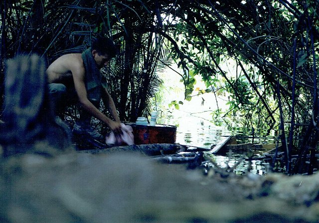 5 Lynn Dalpez washing up in sampan hideout on Cambodian border, Mar 1967